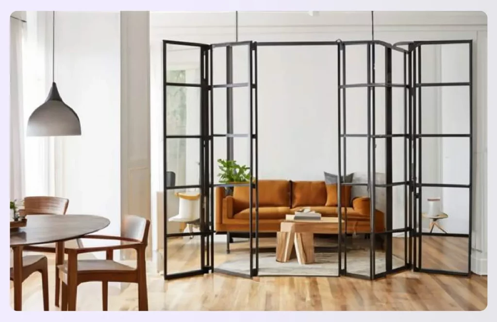 A black-framed collapsible glass partition separating two rooms