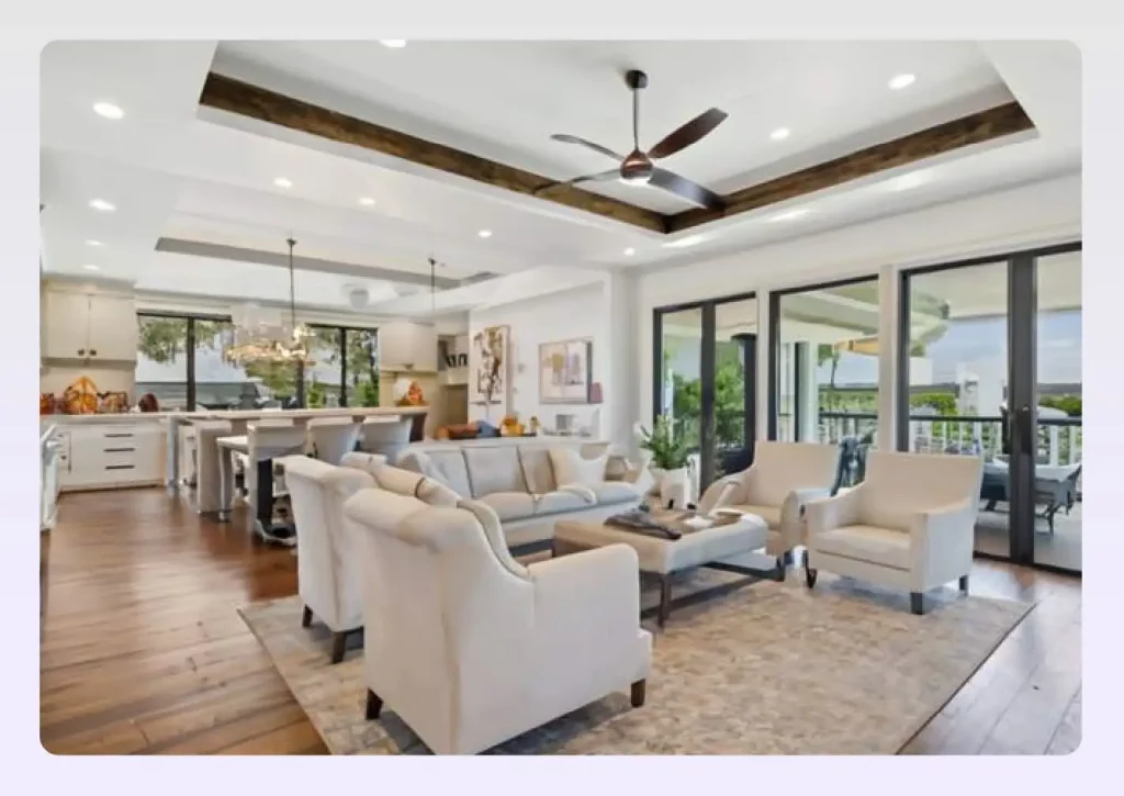 A spacious living area with a tray ceiling fan