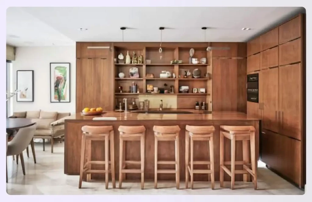 A wooden home bar unit with stools separating spaces