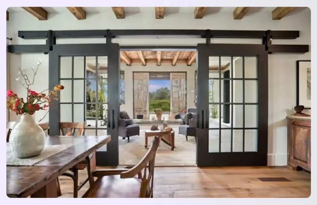 Black sliding barn doors opening into a living room